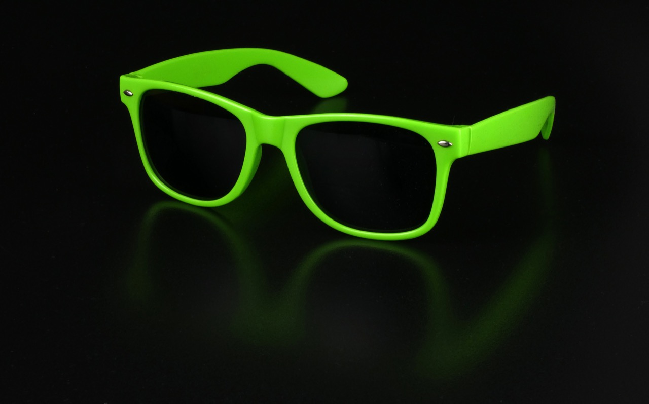 Bright lime-green-framed sunglasses with dark tinted lenses on a black background.